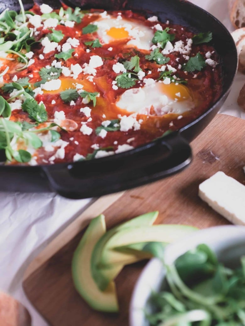 shakshuka in a pan with crumbled cheese