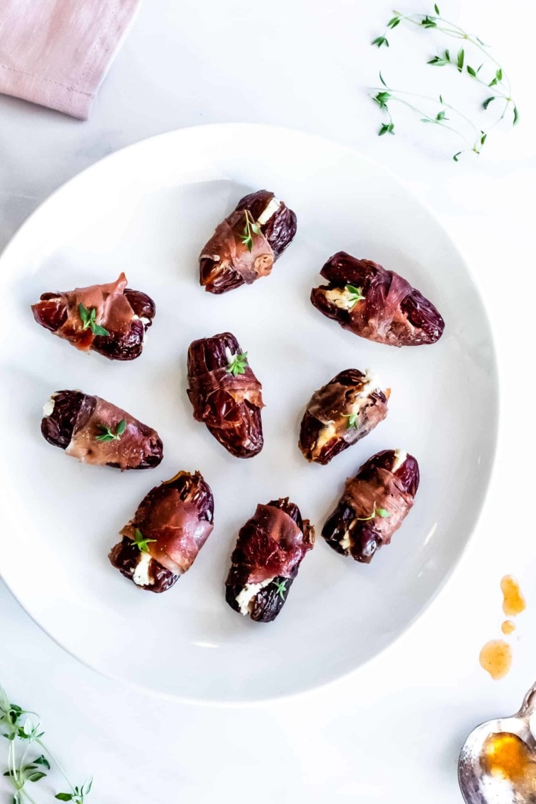 prosciutto wrapped dates on a plate