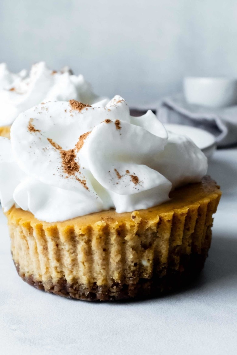 pumpkin cheesecake cupcakes topped with whipped cream