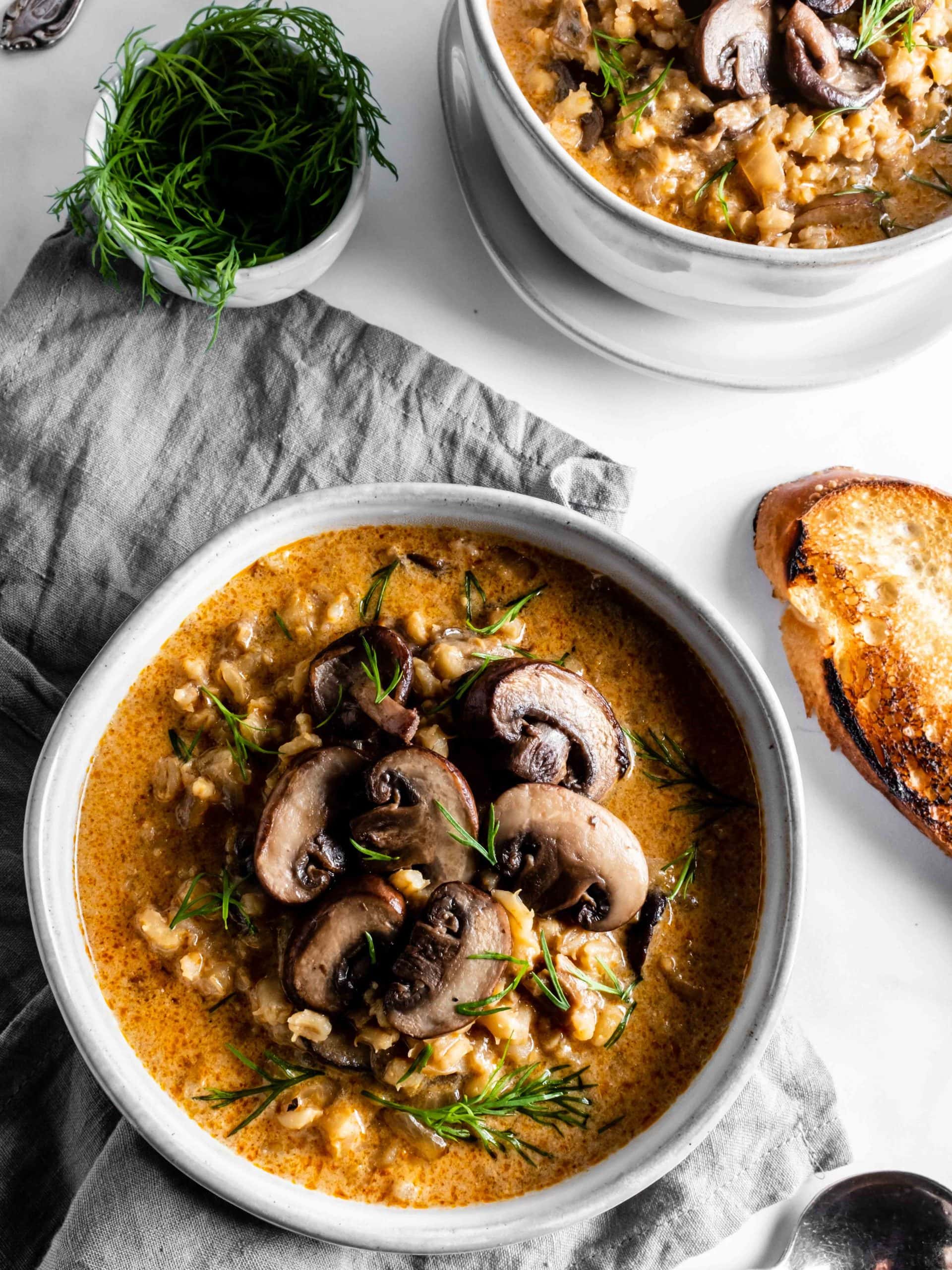 two bowls of barley soup with mushrooms