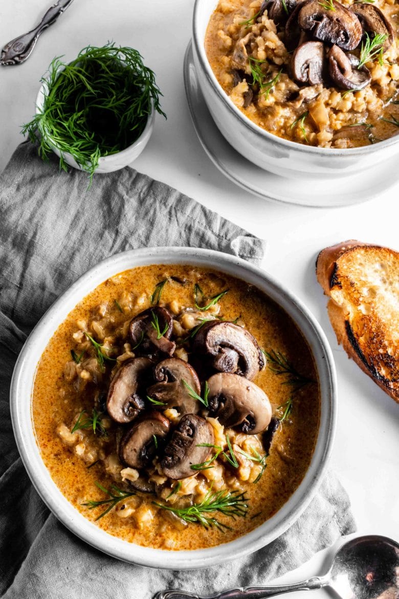 two bowls of barley soup with mushrooms