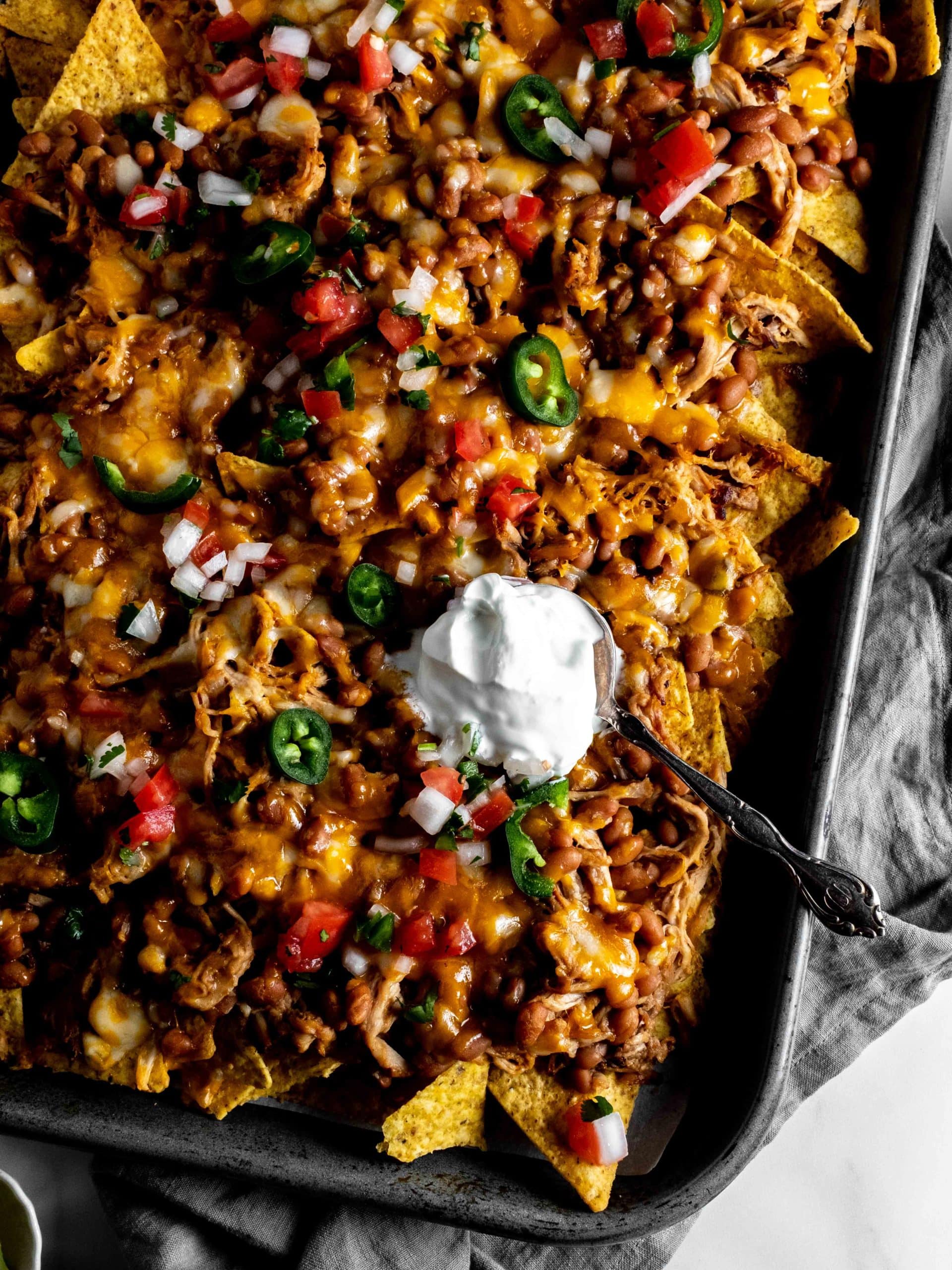 sheet pan nachos with pulled pork, baked beans and cheese