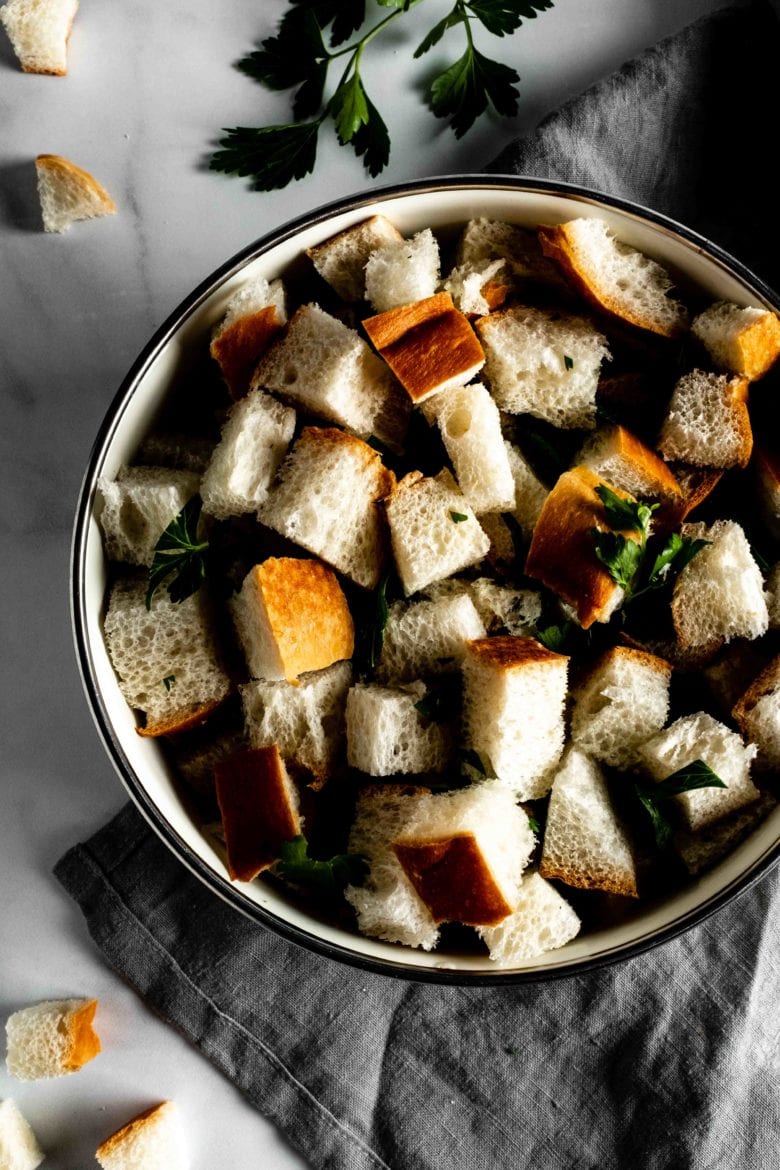 bowl with cubed bread and parsley