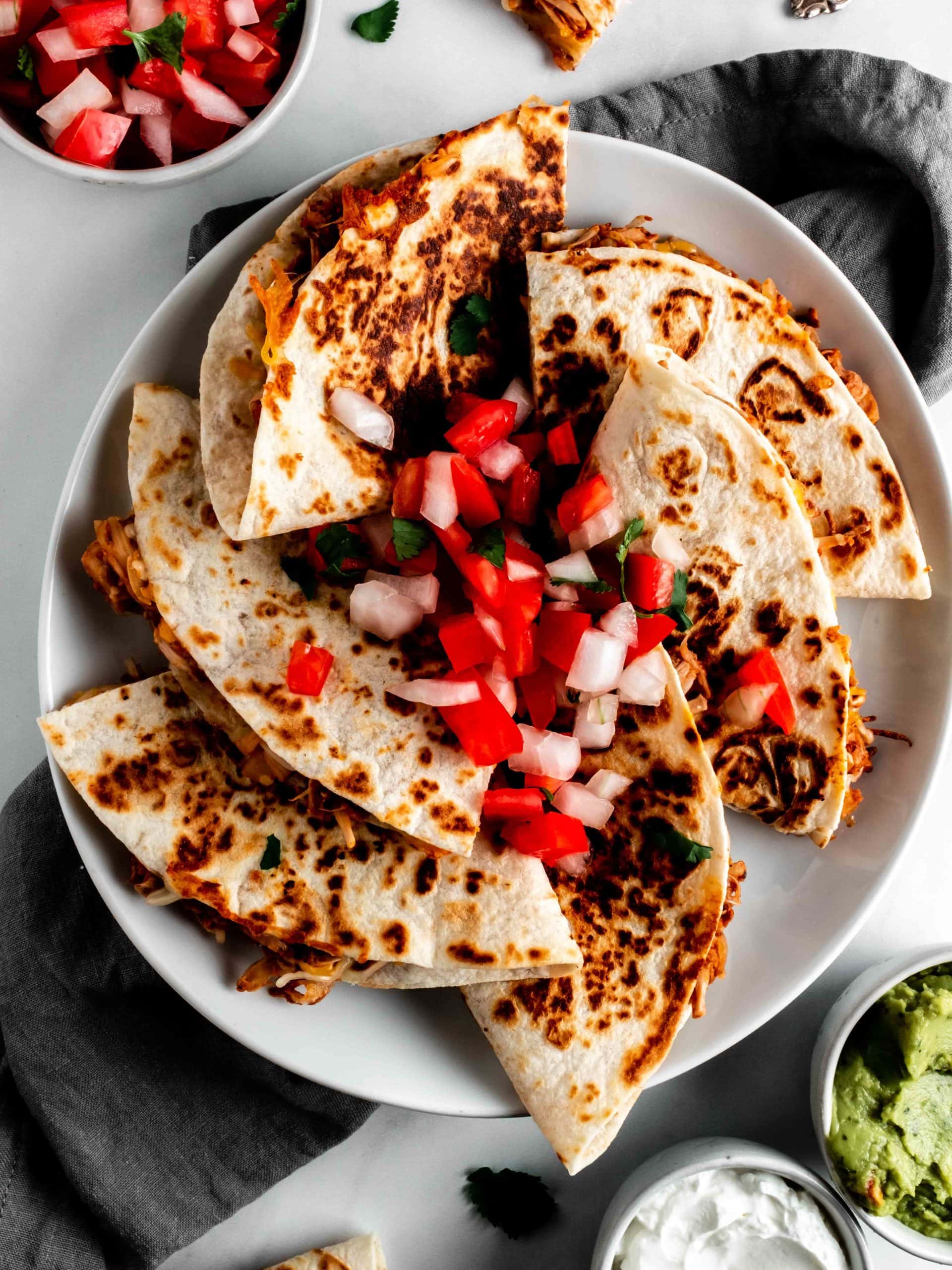 plate of jackfruit quesadillas topped with pico de gallo