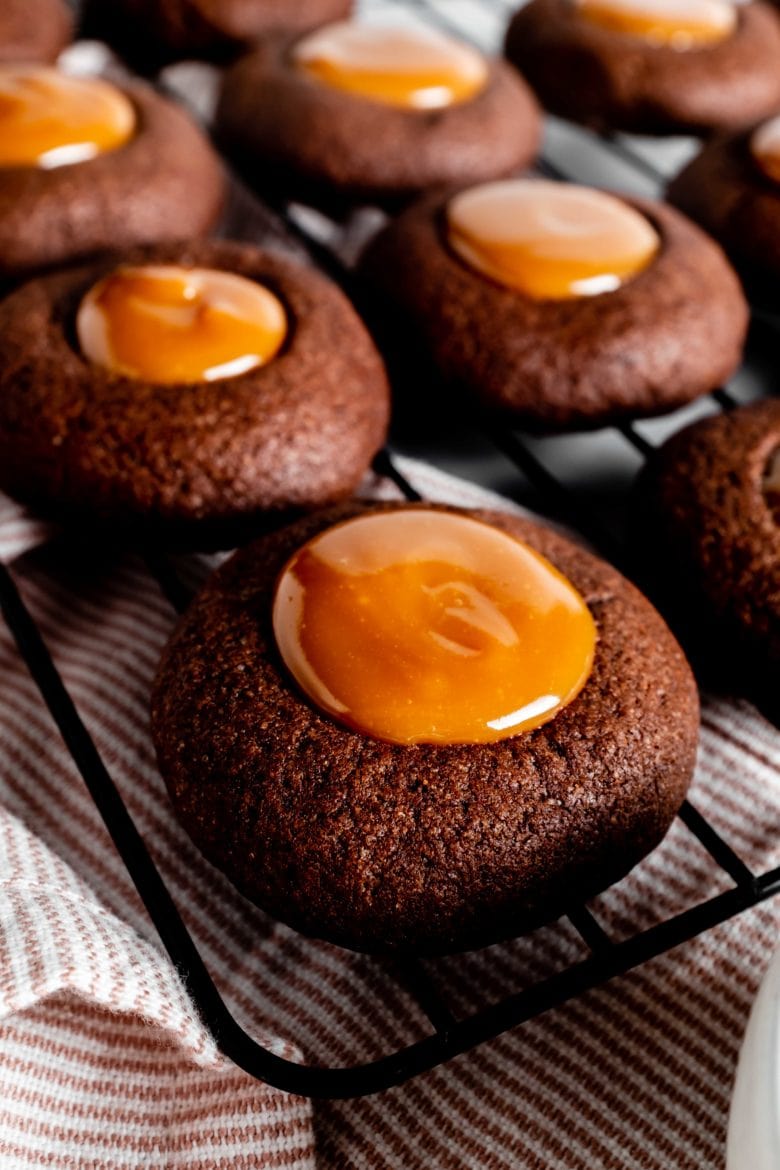 close up of chocolate thumbprint cookie with dulce de leche filling