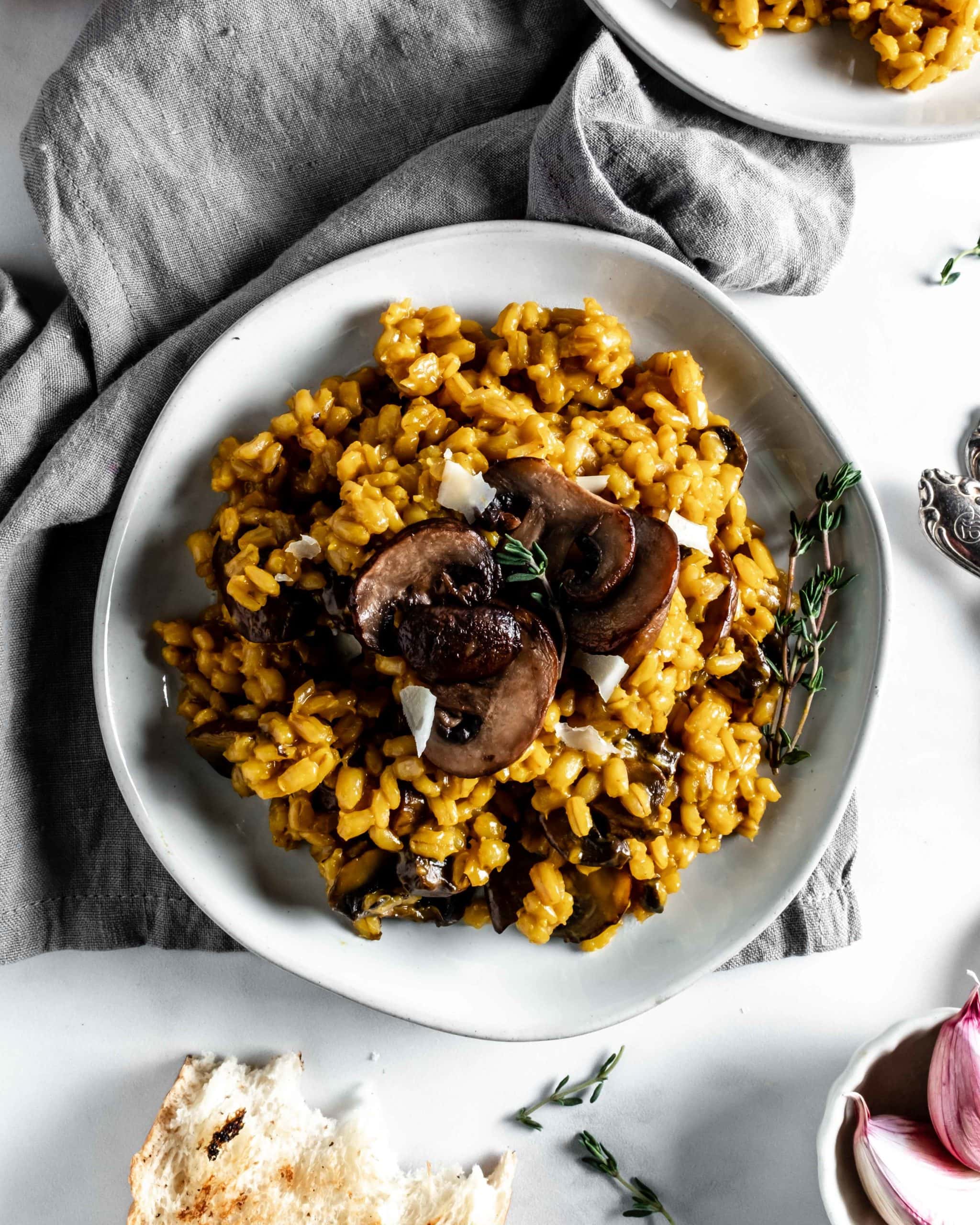 plate of saffron barley risotto topped with mushrooms