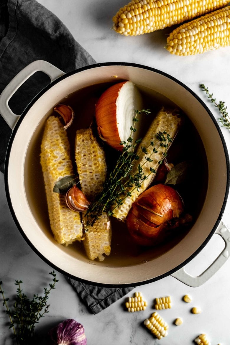 pot with corn cobs, onion and thyme