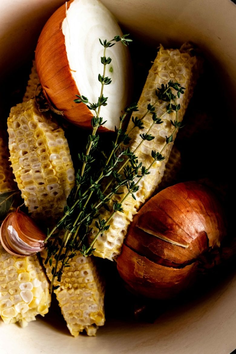 pot with corn cobs, onion and thyme