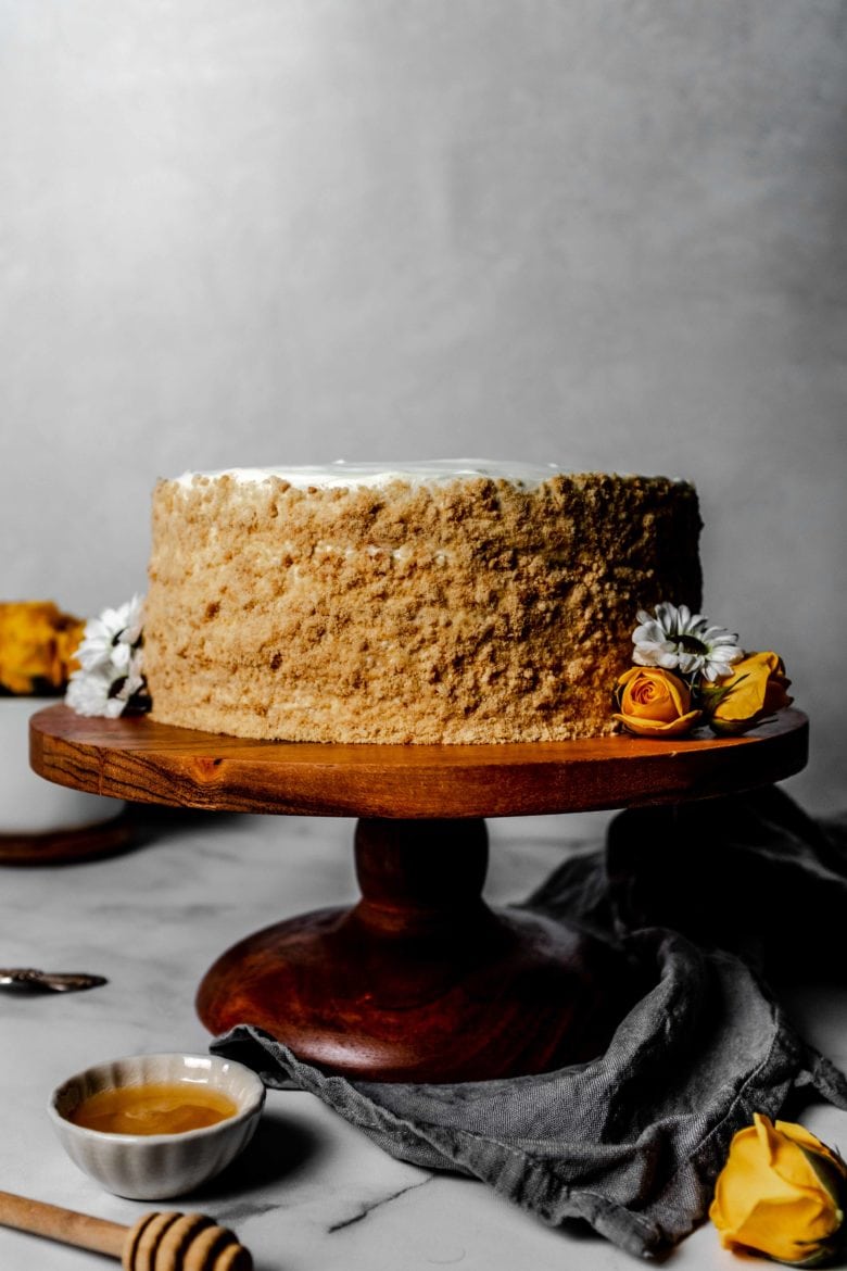 medovik on a cake stand with flowers and honey