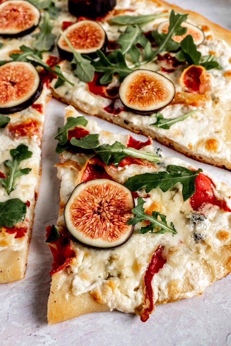 slice of pizza with fresh figs and arugula