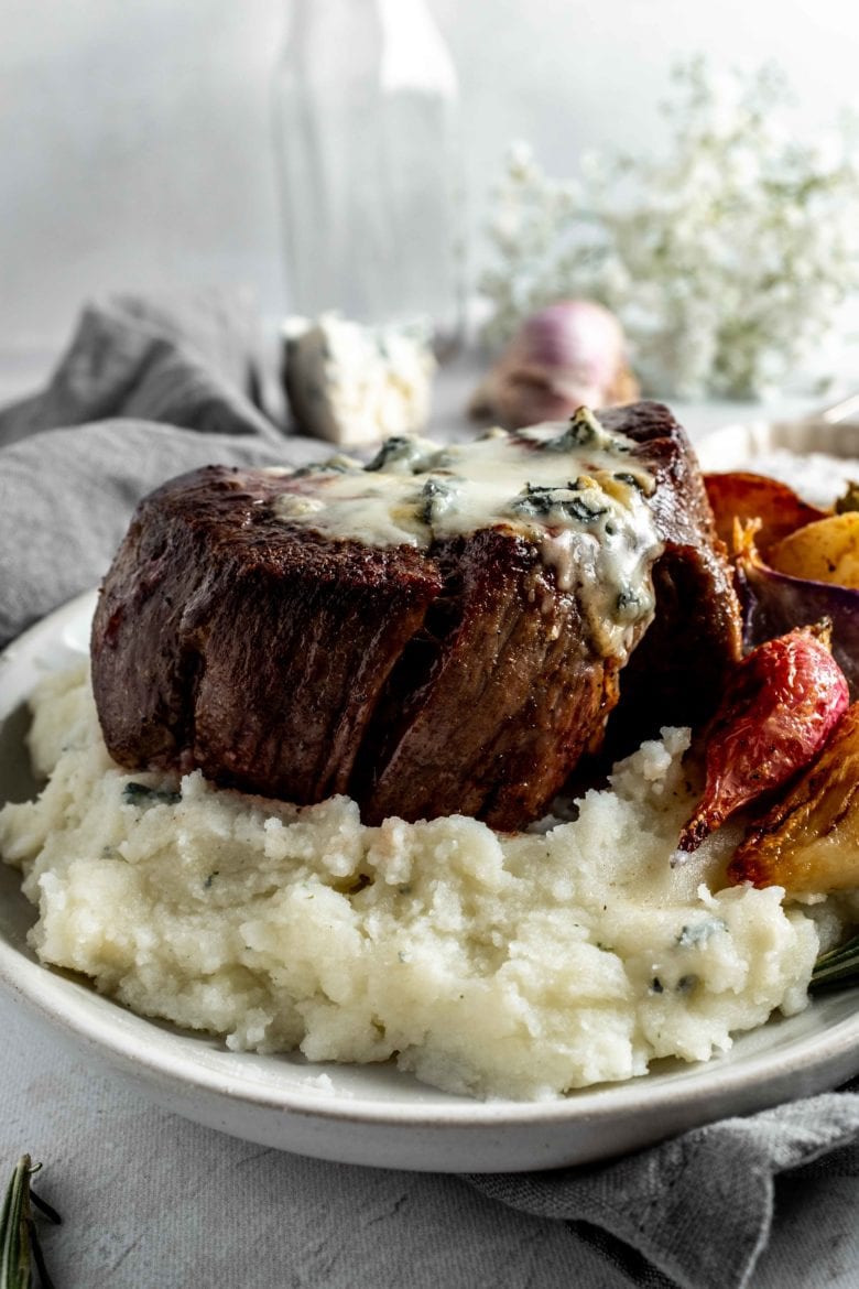 filet mignon covered in gorgonzola over mashed potatoes