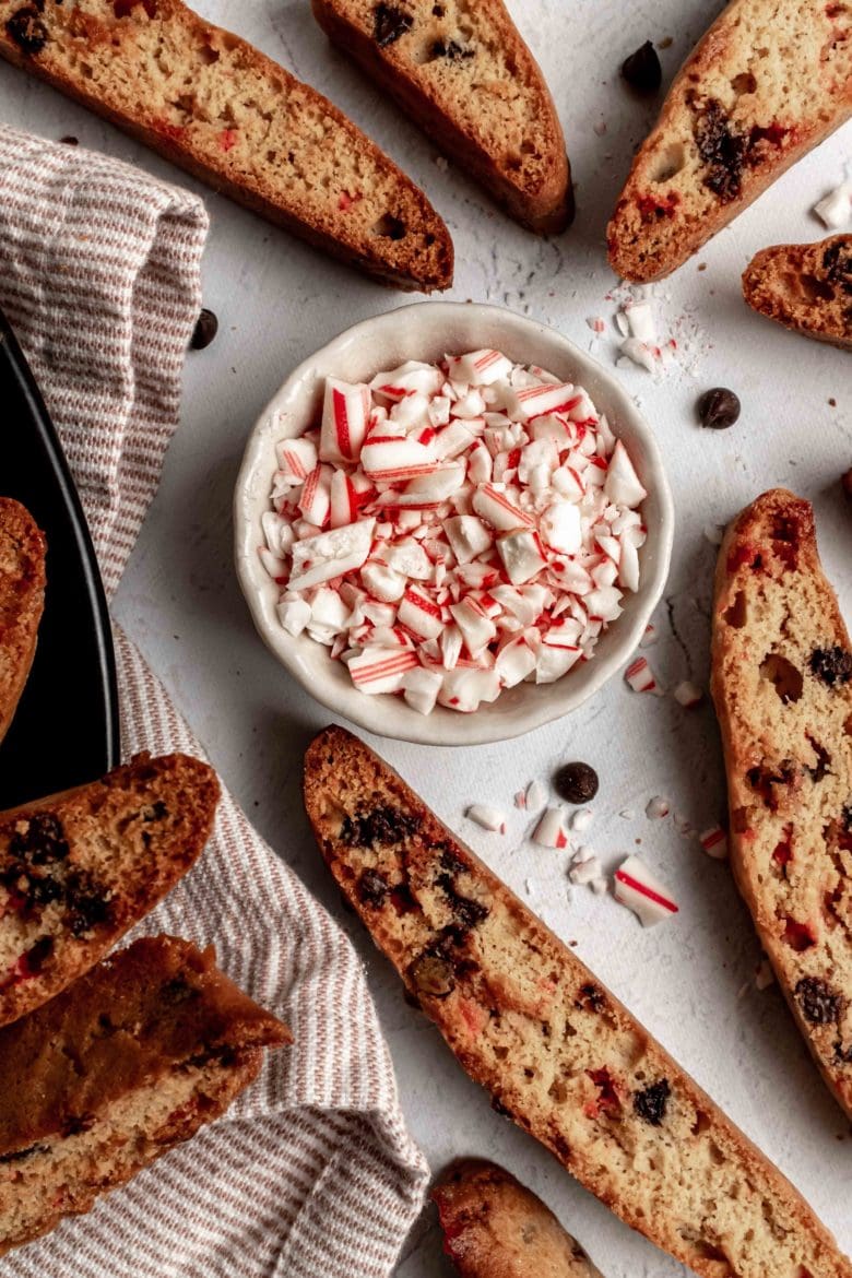 peppermint chocolate biscotti with bowl of crushed candy canes