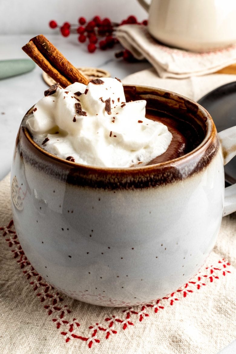 cup of espresso sipping chocolate with whipped cream and cinnamon stick