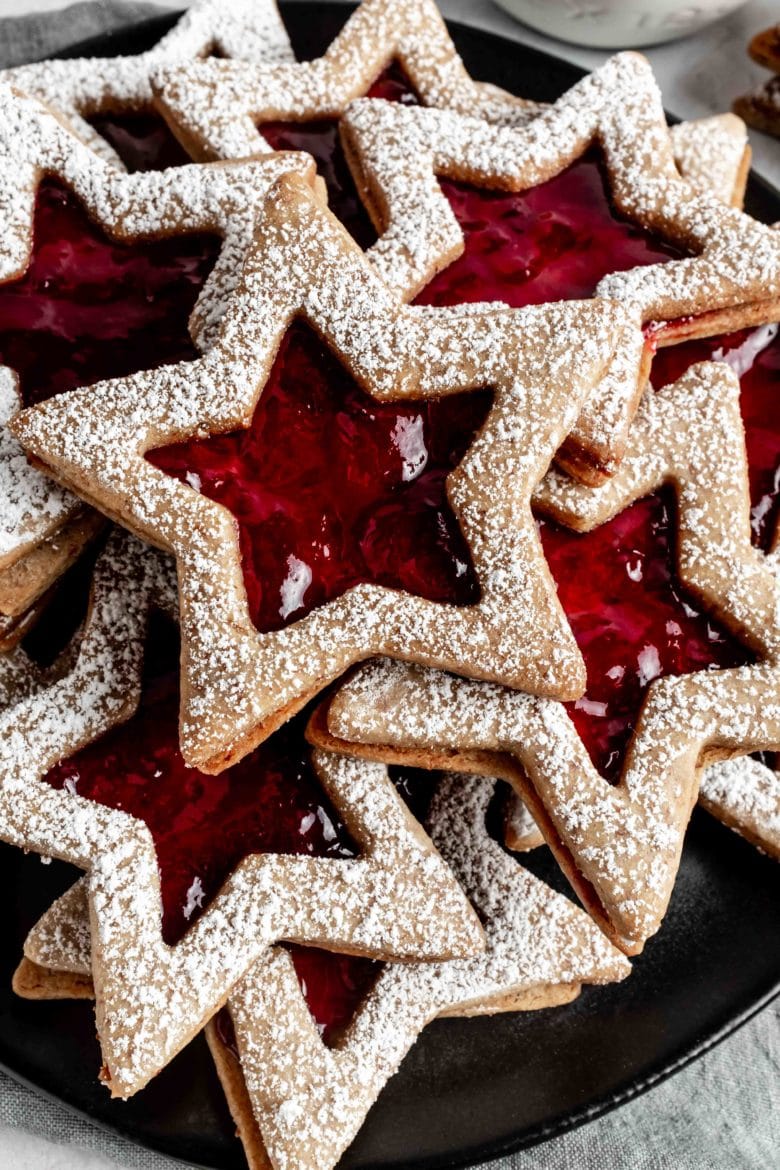 linzer cookies dusted with powdered sugar on a plate