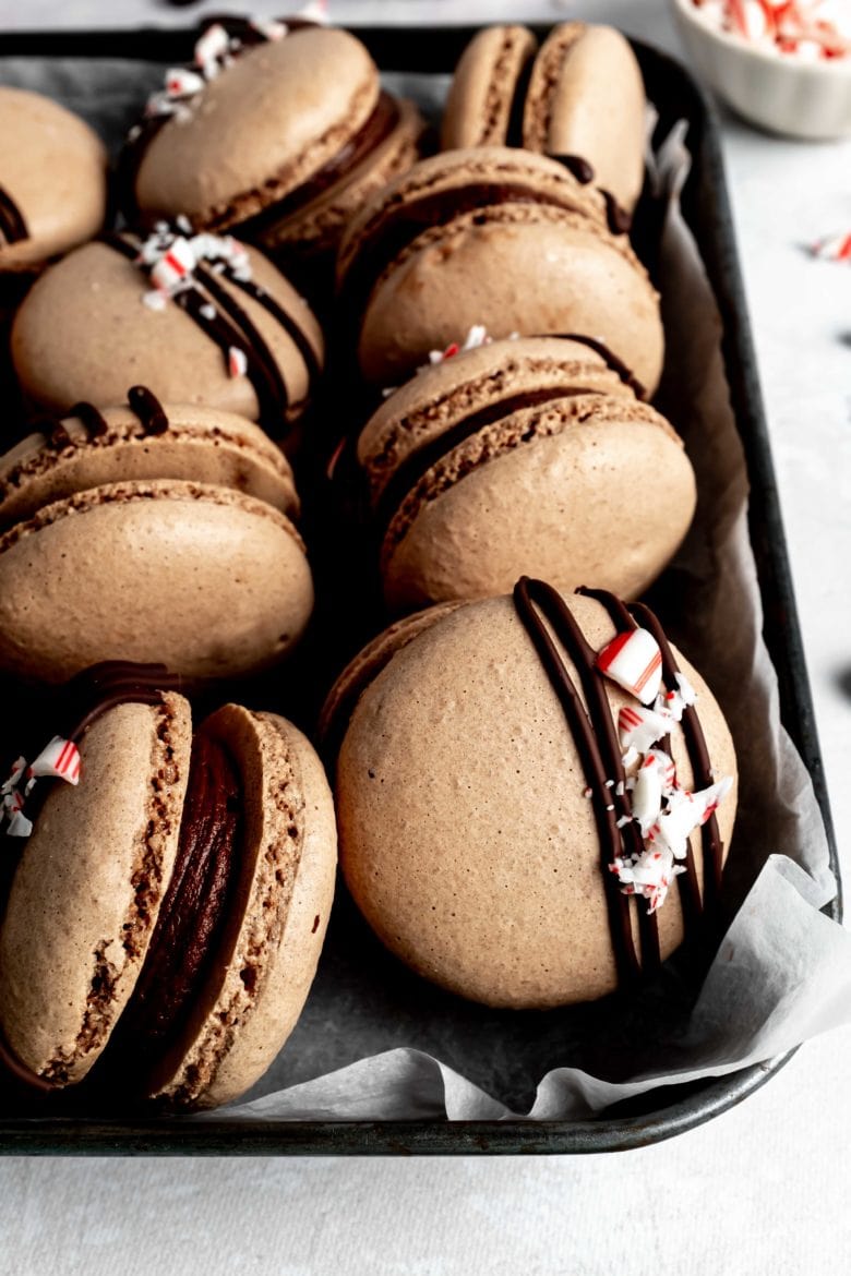 tin of macarons with chocolate drizzle and crushed peppermint
