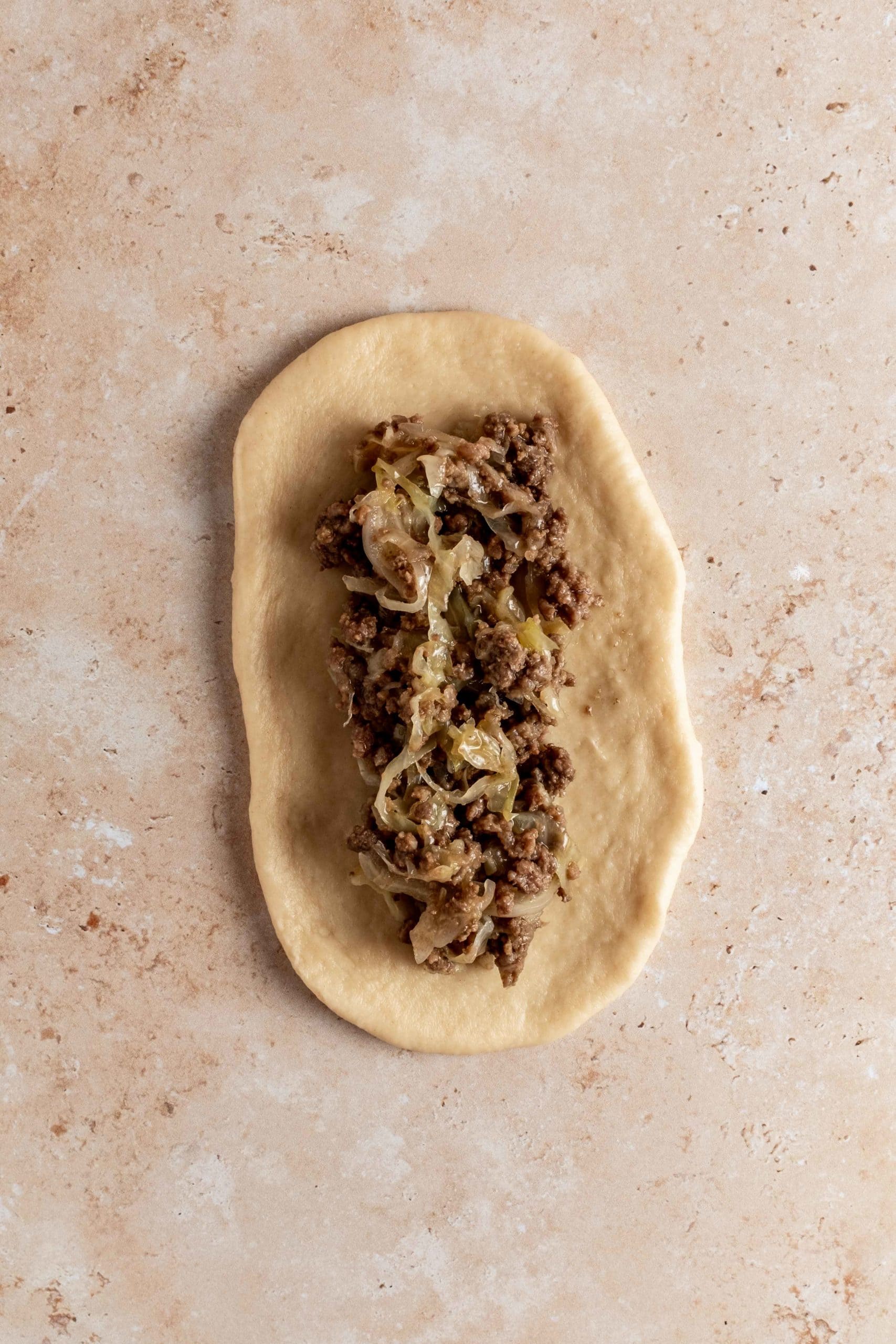 rolled out dough with beef and cabbage mixture