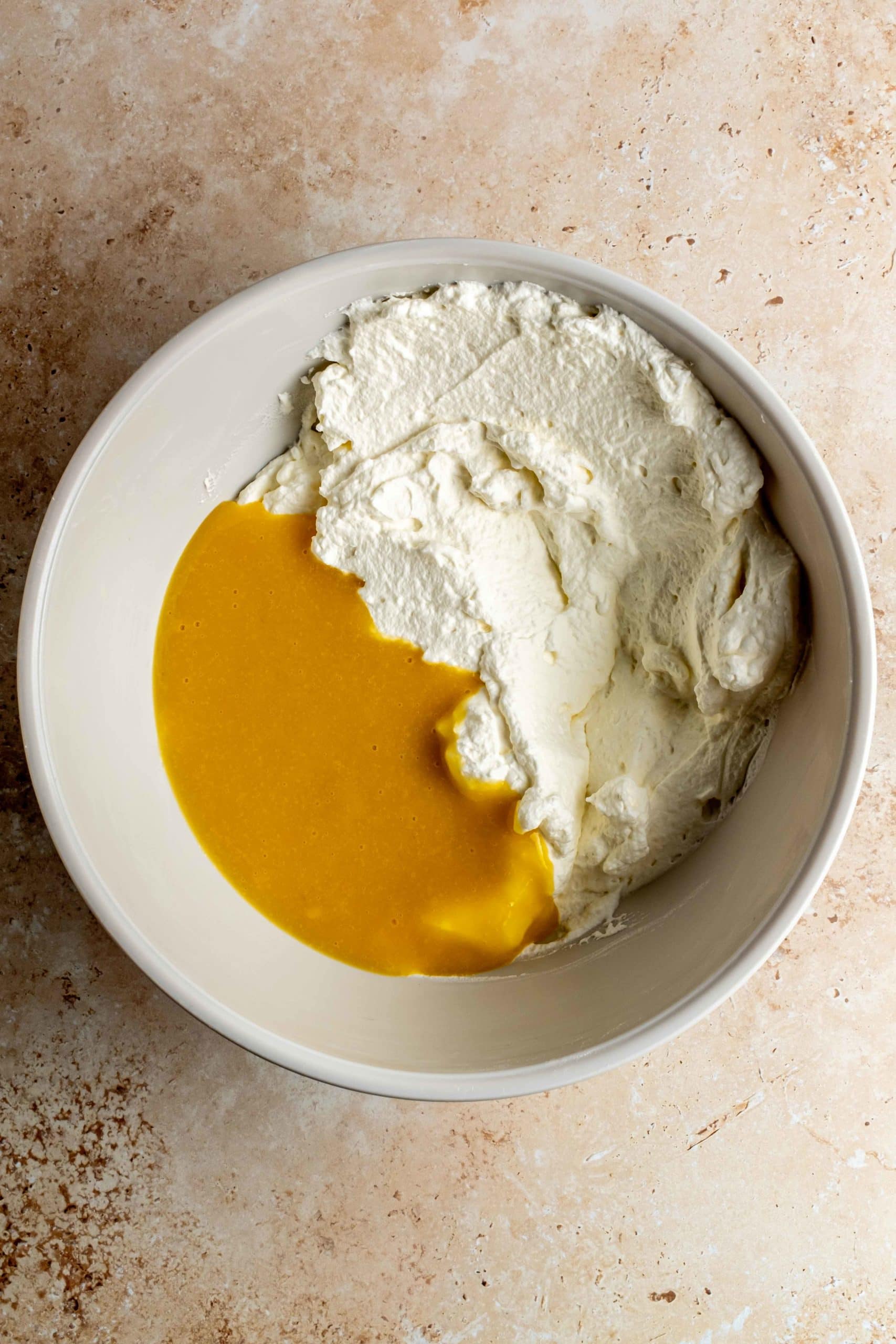 mixing mango puree with whipped cream