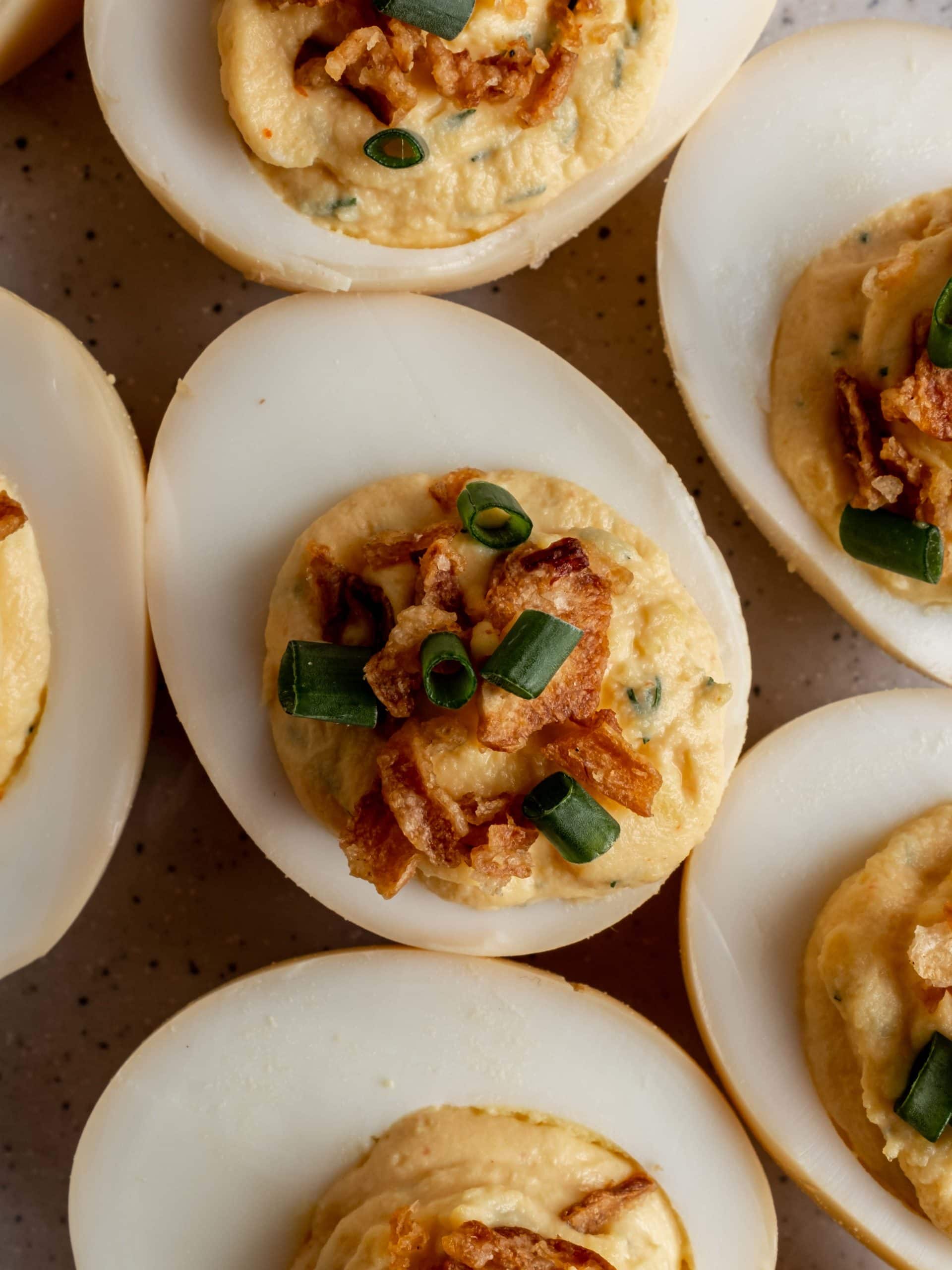 close up of deviled egg with crispy onions and green onions