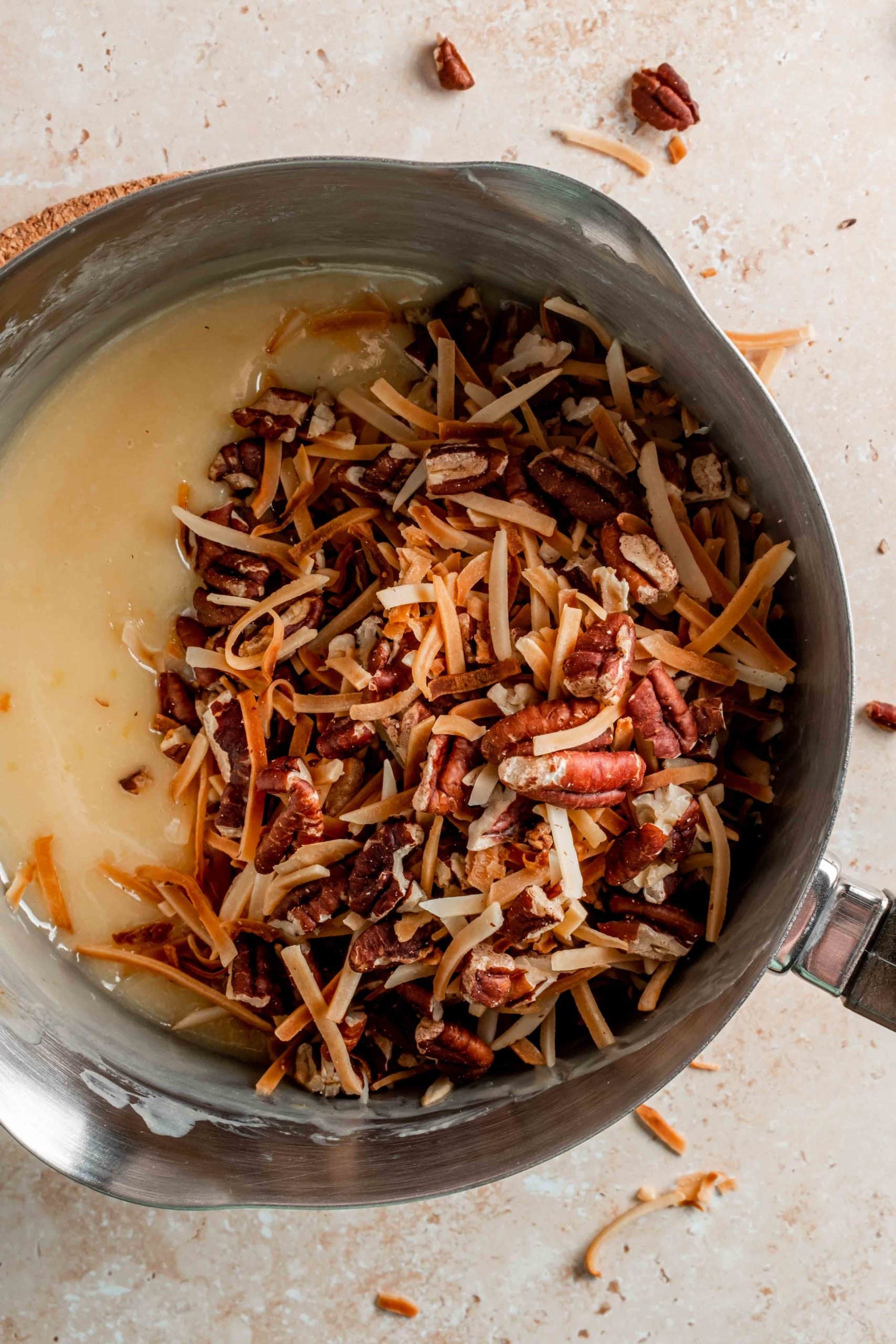 toasted coconut flakes and pecans in saucepan