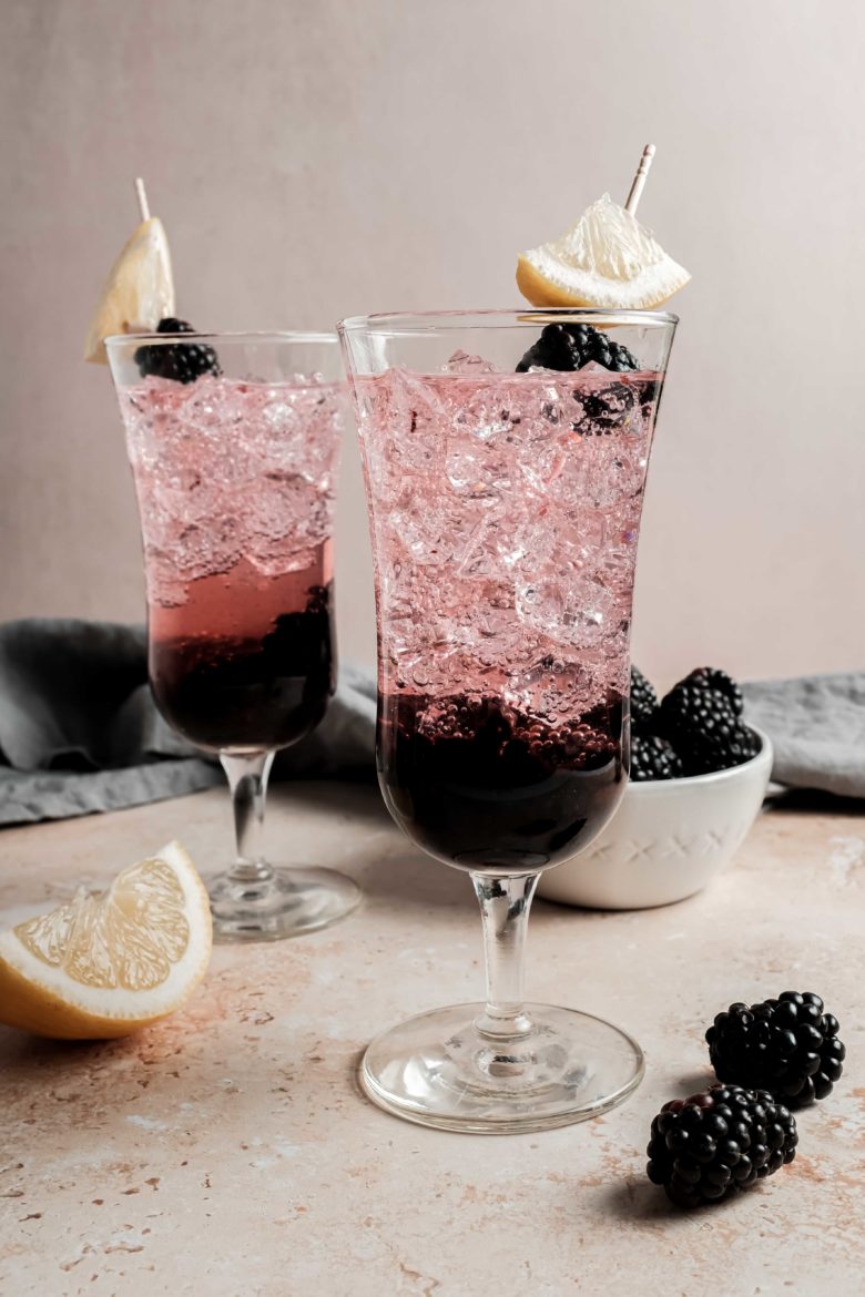 cocktails garnished with lemon and blackberry