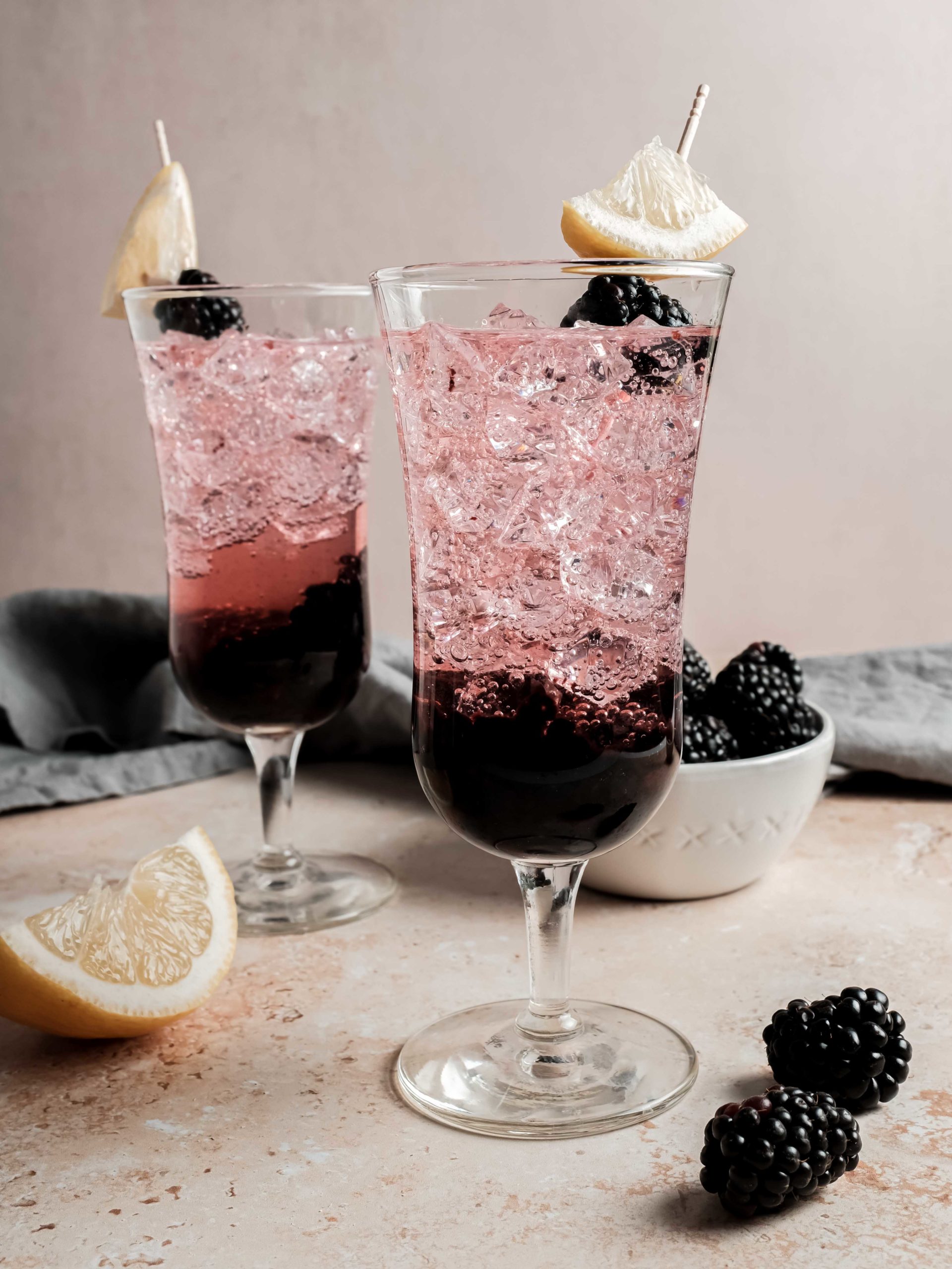 cocktails garnished with lemon and blackberry