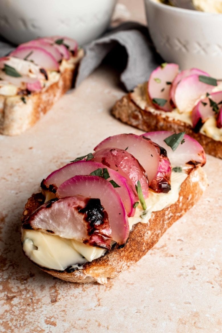 sliced radish on baguette with herb butter