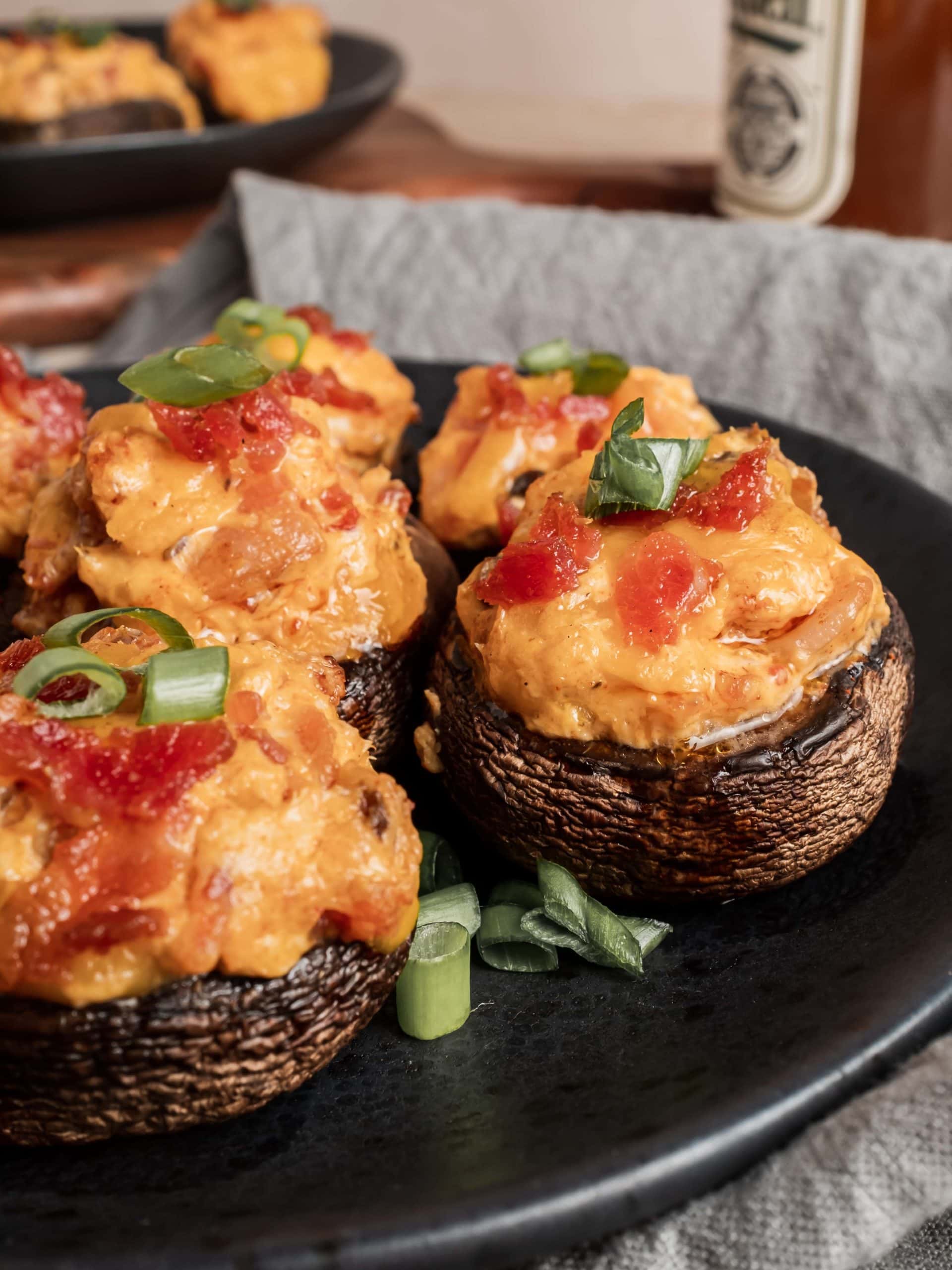 bacon stuffed mushrooms garnished with green onion on plate