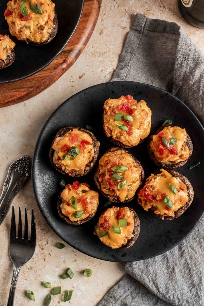 bacon stuffed mushrooms garnished with green onion on plate