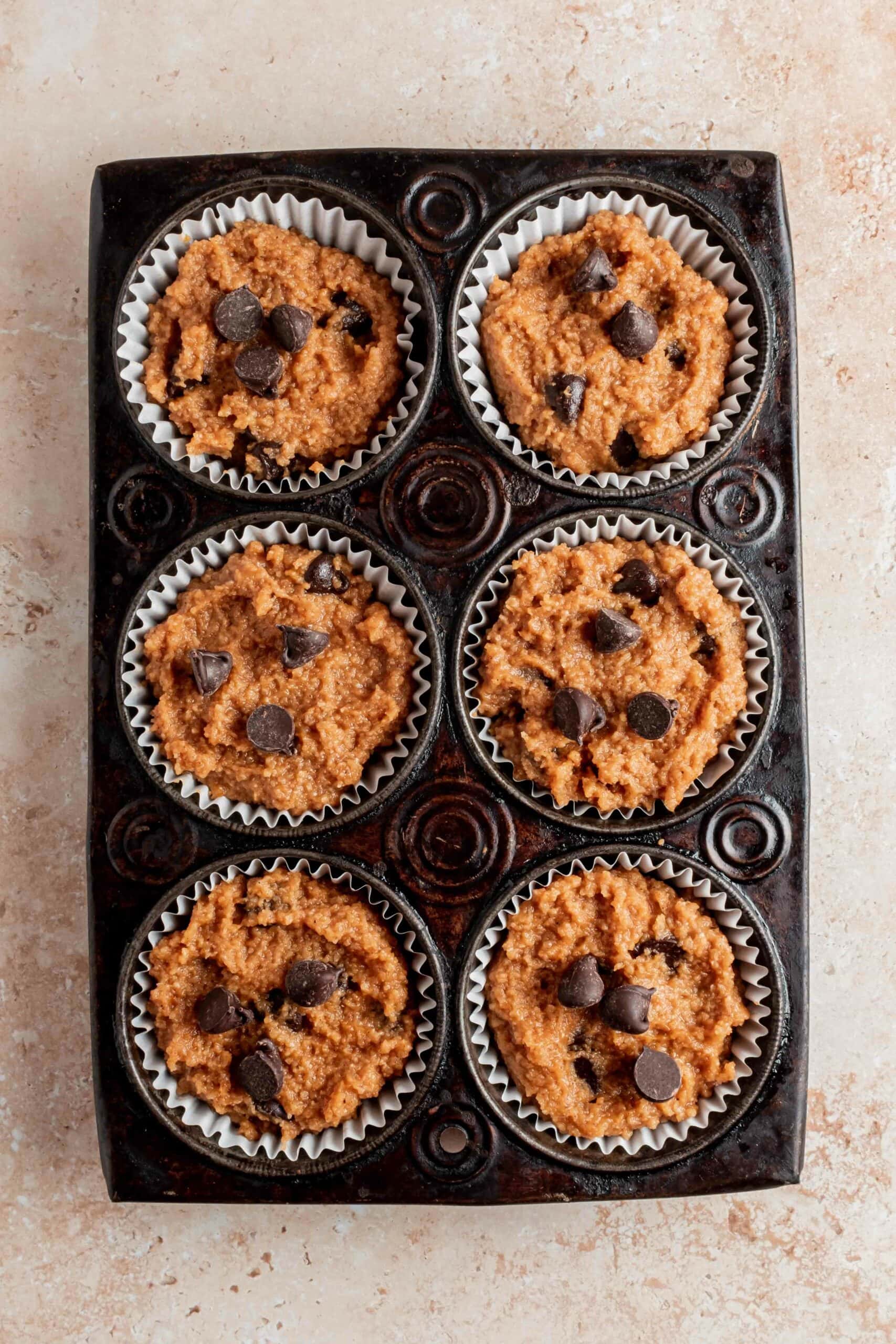 pumpkin batter in muffin tin topped with chocolate chips
