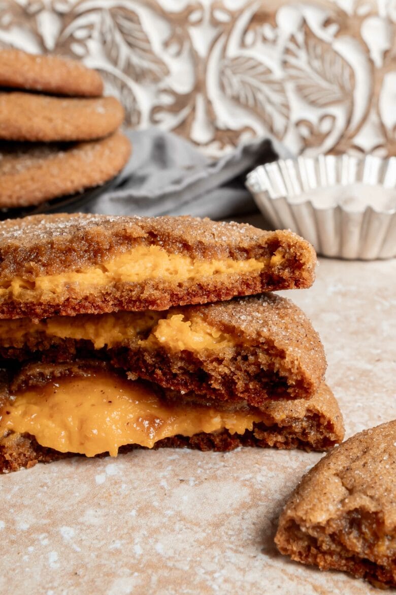 stack of spice cookies showing cross section with pumpkin cheesecake filling