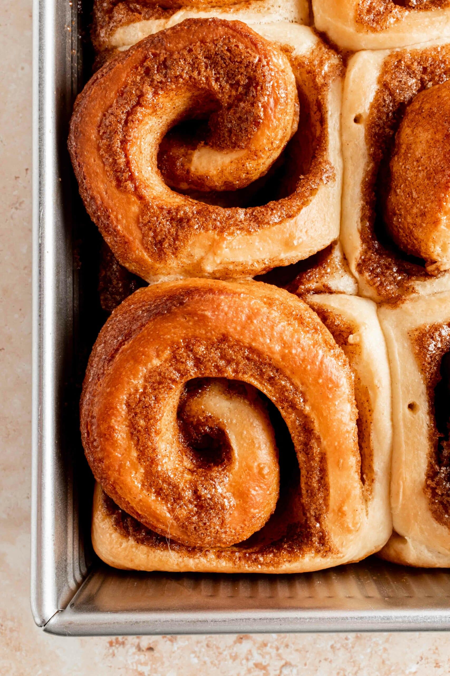 close up of baked cinnamon rolls in pan