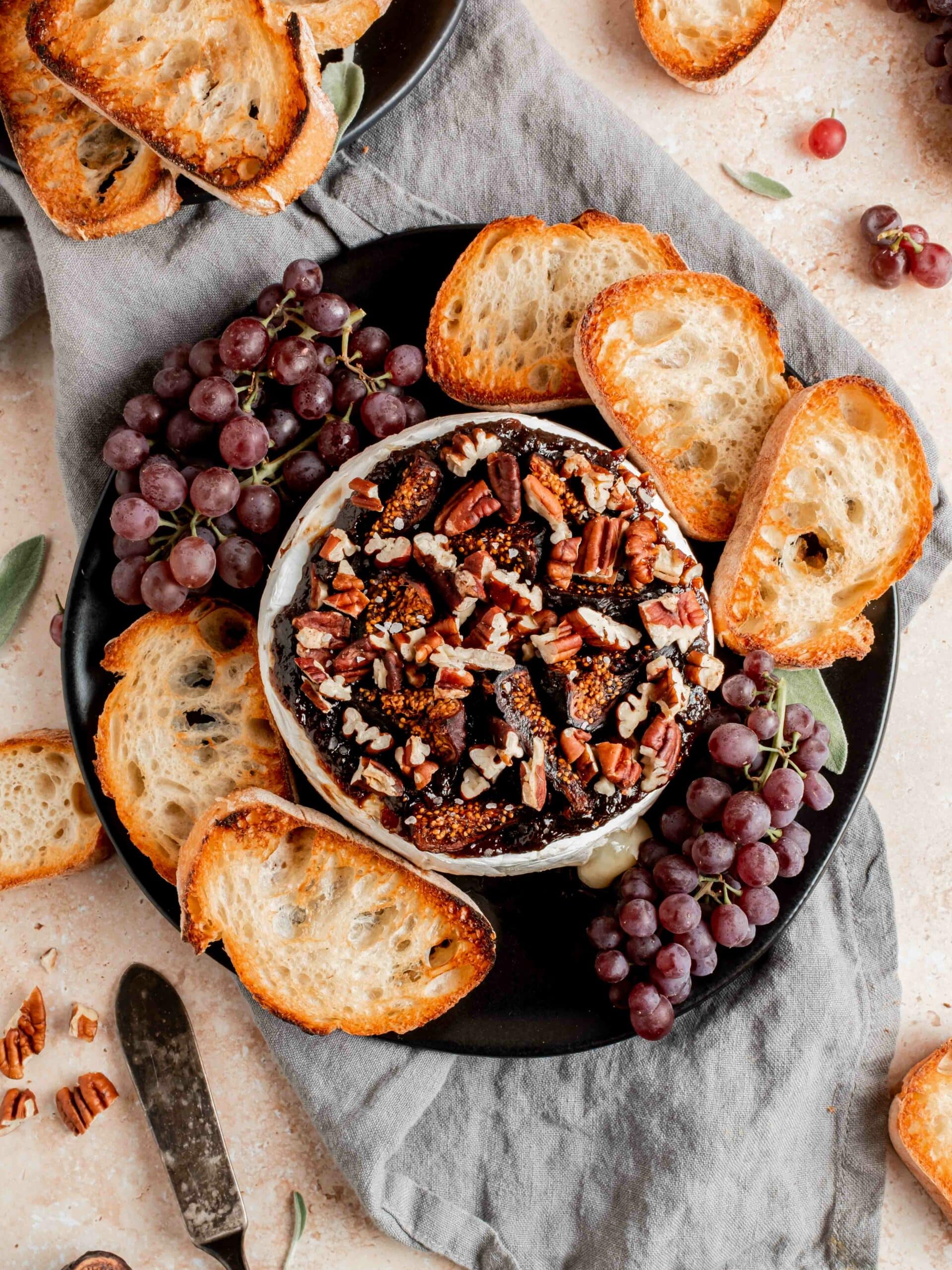 platter with brie, crostini and grapes