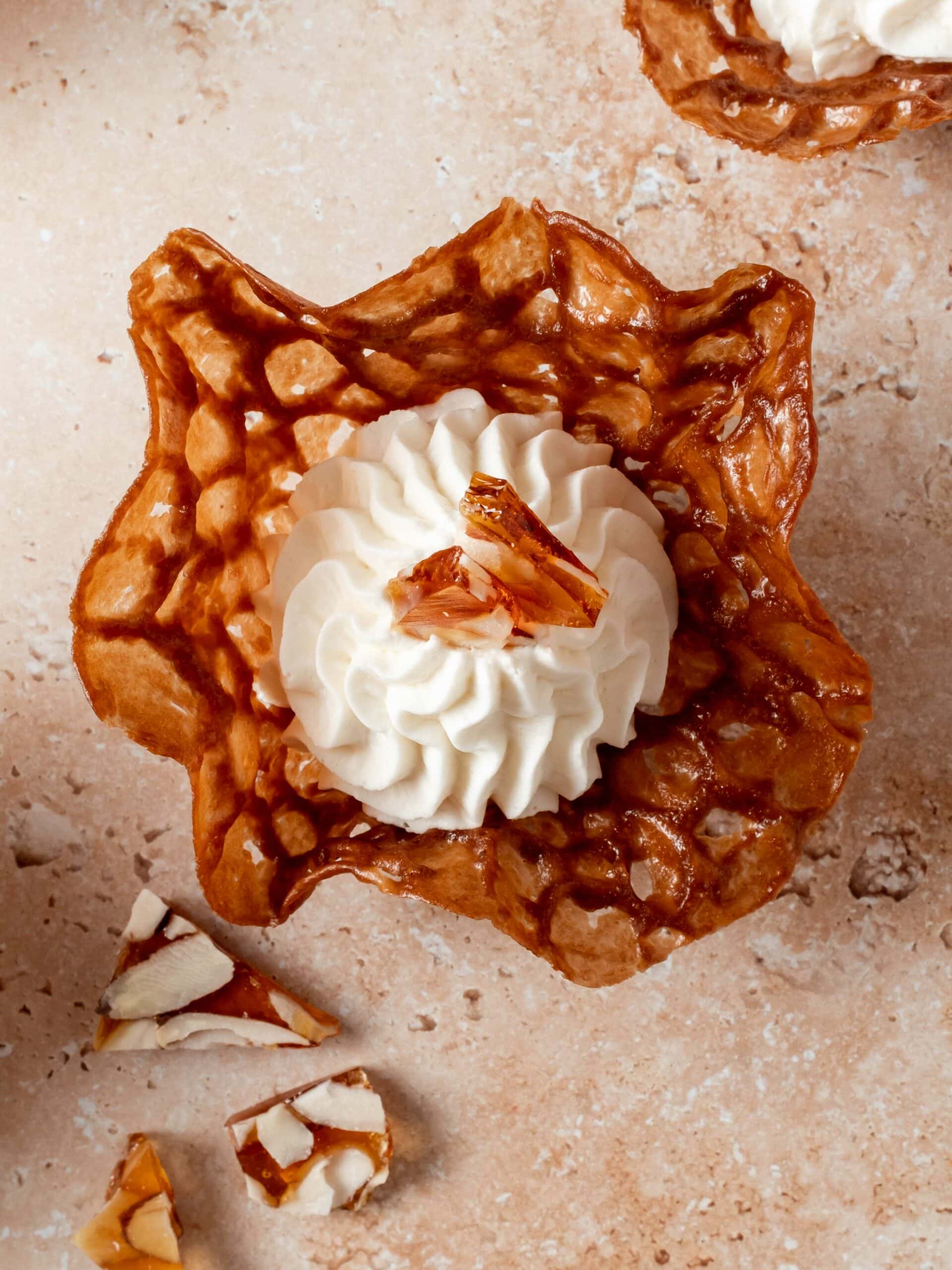 top down view of a brandy snap basket with with mascarpone whipped cream and praline