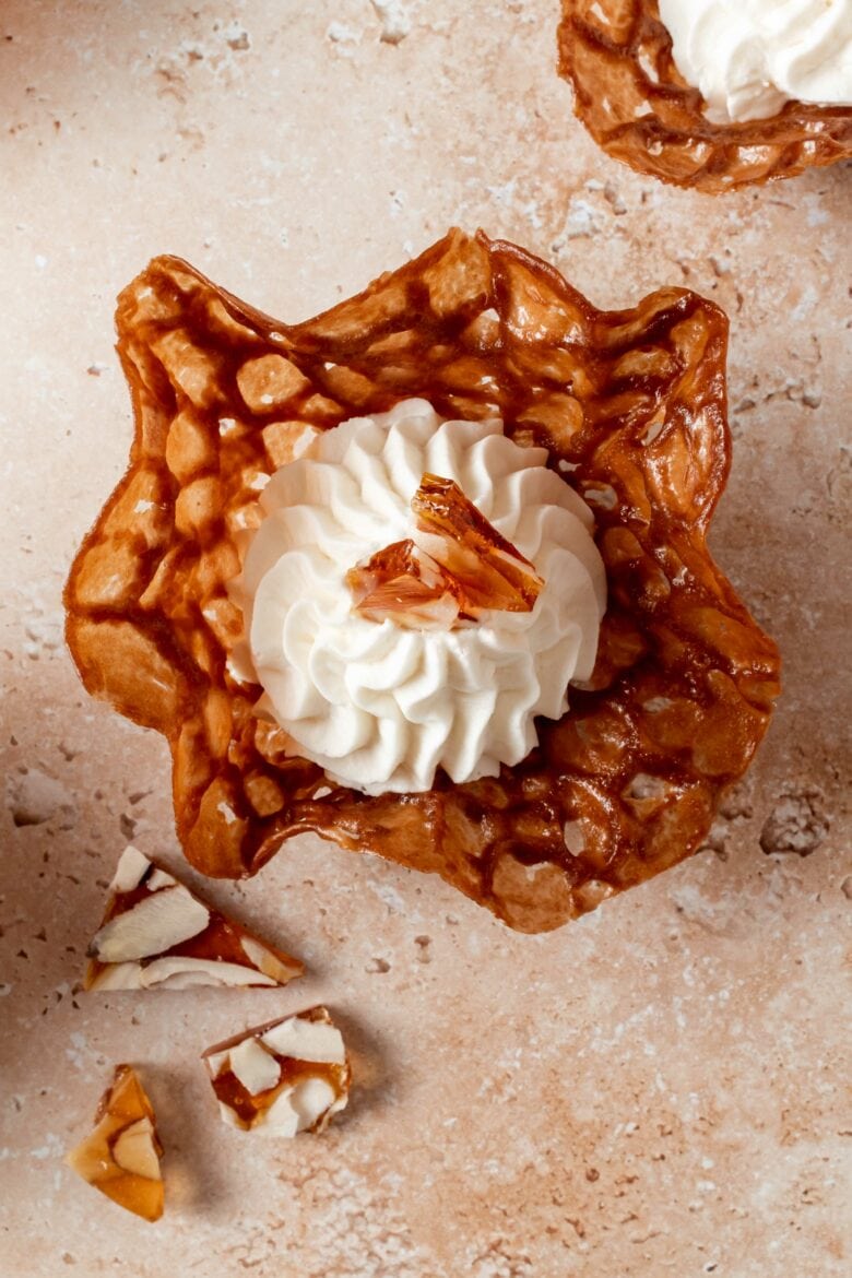 top down view of a brandy snap basket with with mascarpone whipped cream and praline