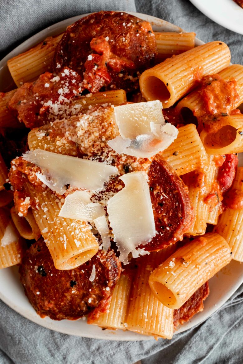 overhead view of pasta on plate with creamy tomato sauce, chorizo and parmesan