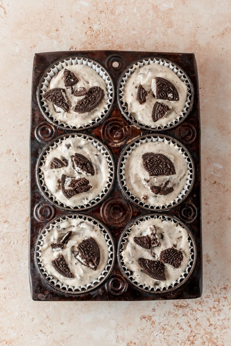 unbaked mini cheesecakes in tin with cookie topping