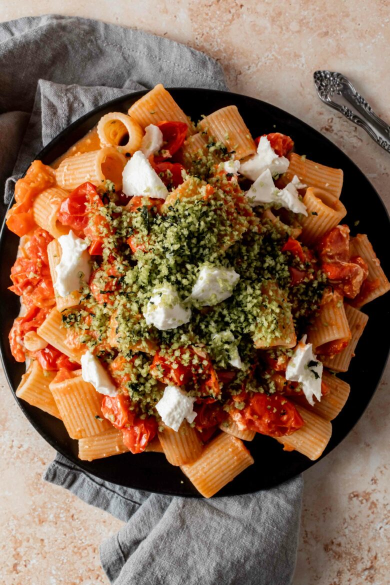 pasta in tomato sauce topped with basil breadcrumbs and burrata