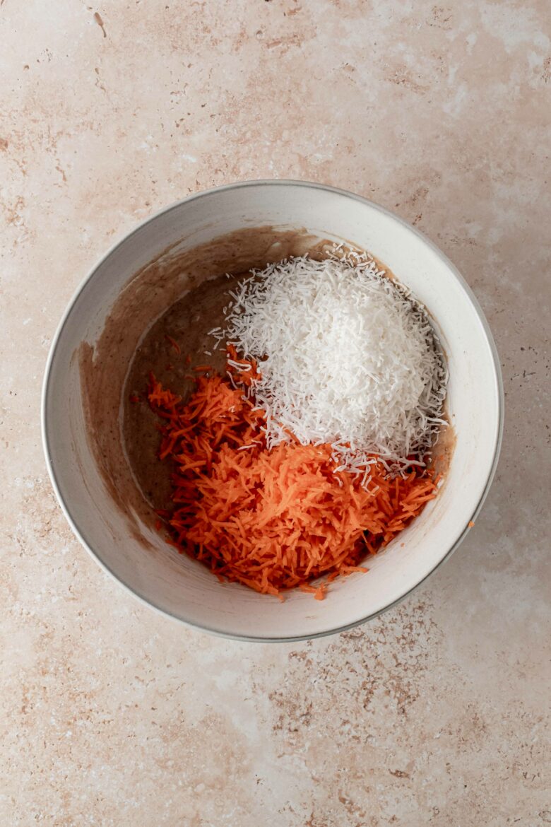 Mixing the shredded carrots and coconut into the batter