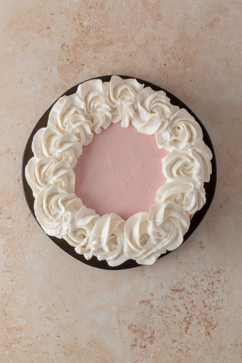 overhead view of strawberry mousse cake with whipped cream
