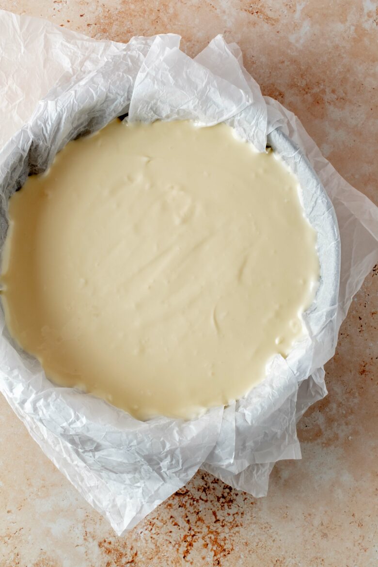 Cheesecake batter in springform pan lined with parchment paper