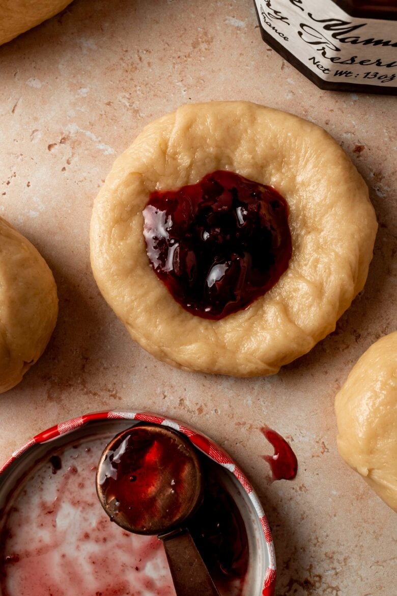 spoonful of cherry preserves on a round of dough