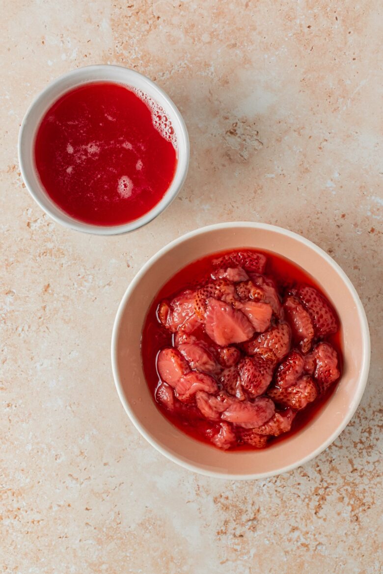 bowl of strawberry syrup and dish with strained strawberry pieces