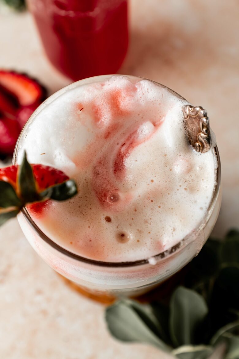 frothed milk in a glass with strawberry syrup