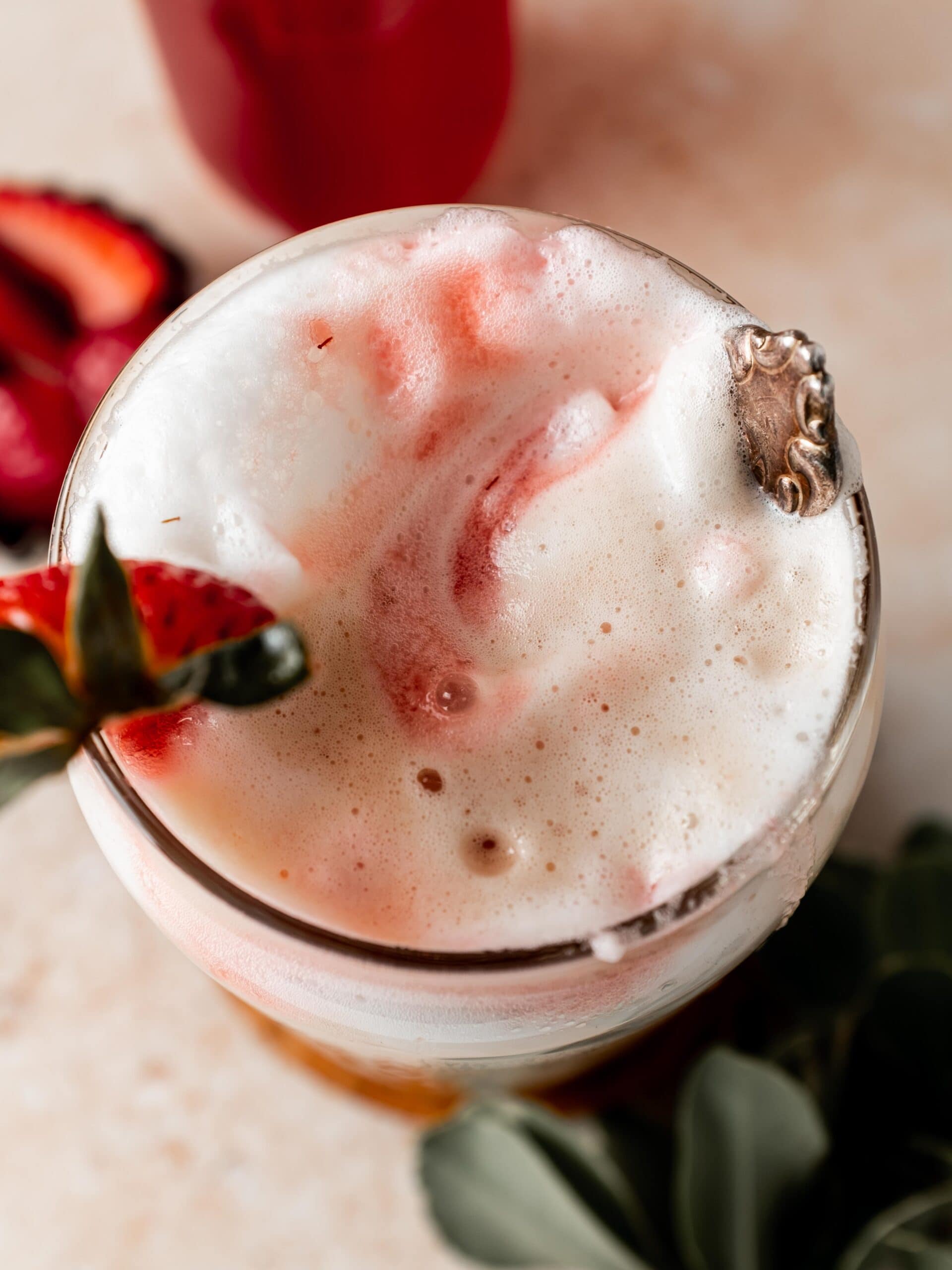 creamy iced coffee with frothy milk and strawberry syrup