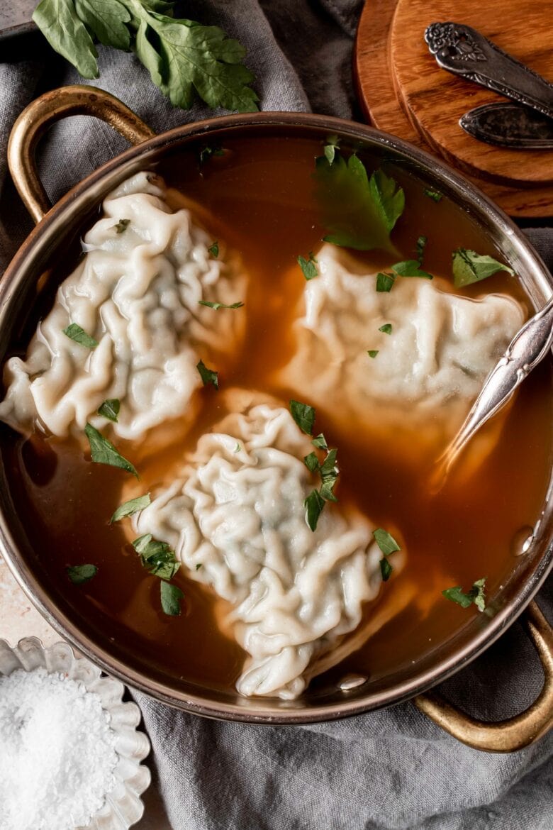 three large maultaschen in bowl of broth