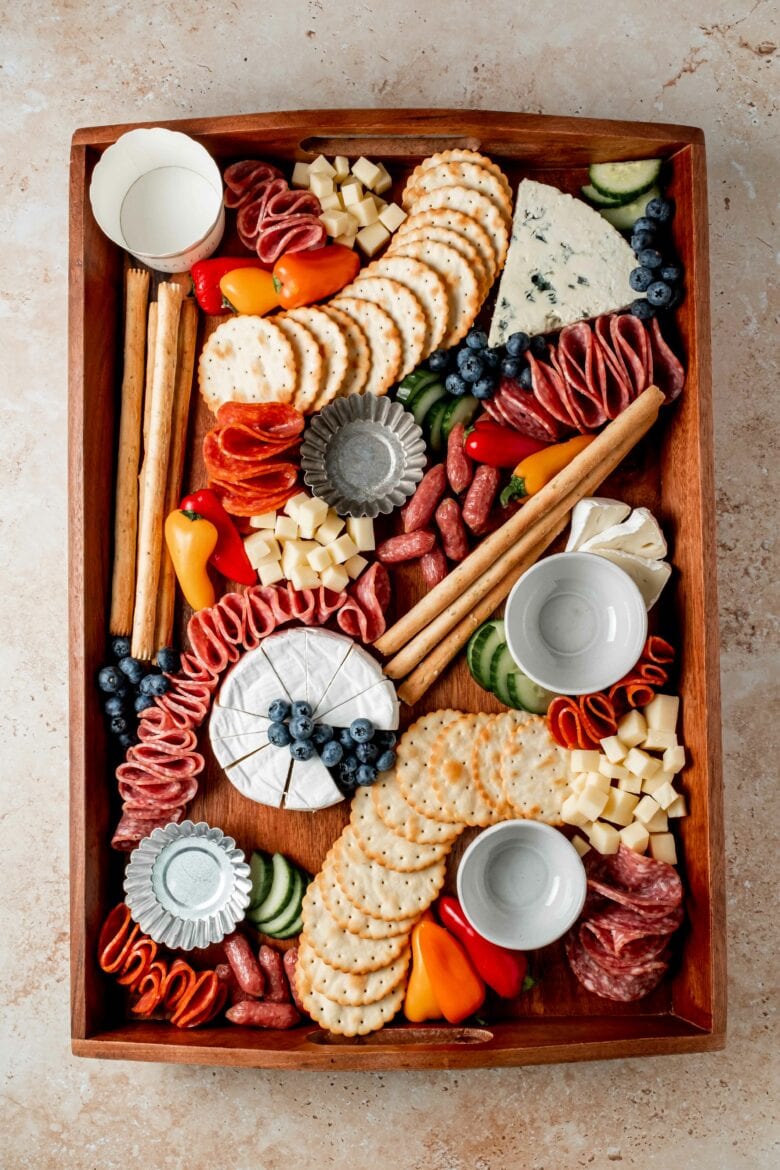 Adding fresh fruits and vegetables to the charcuterie board.