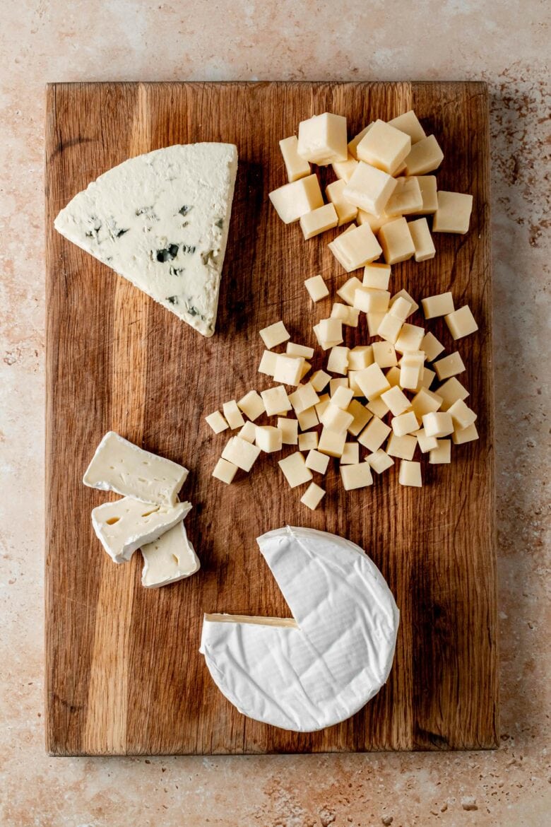 Three cheeses cut into different shapes.