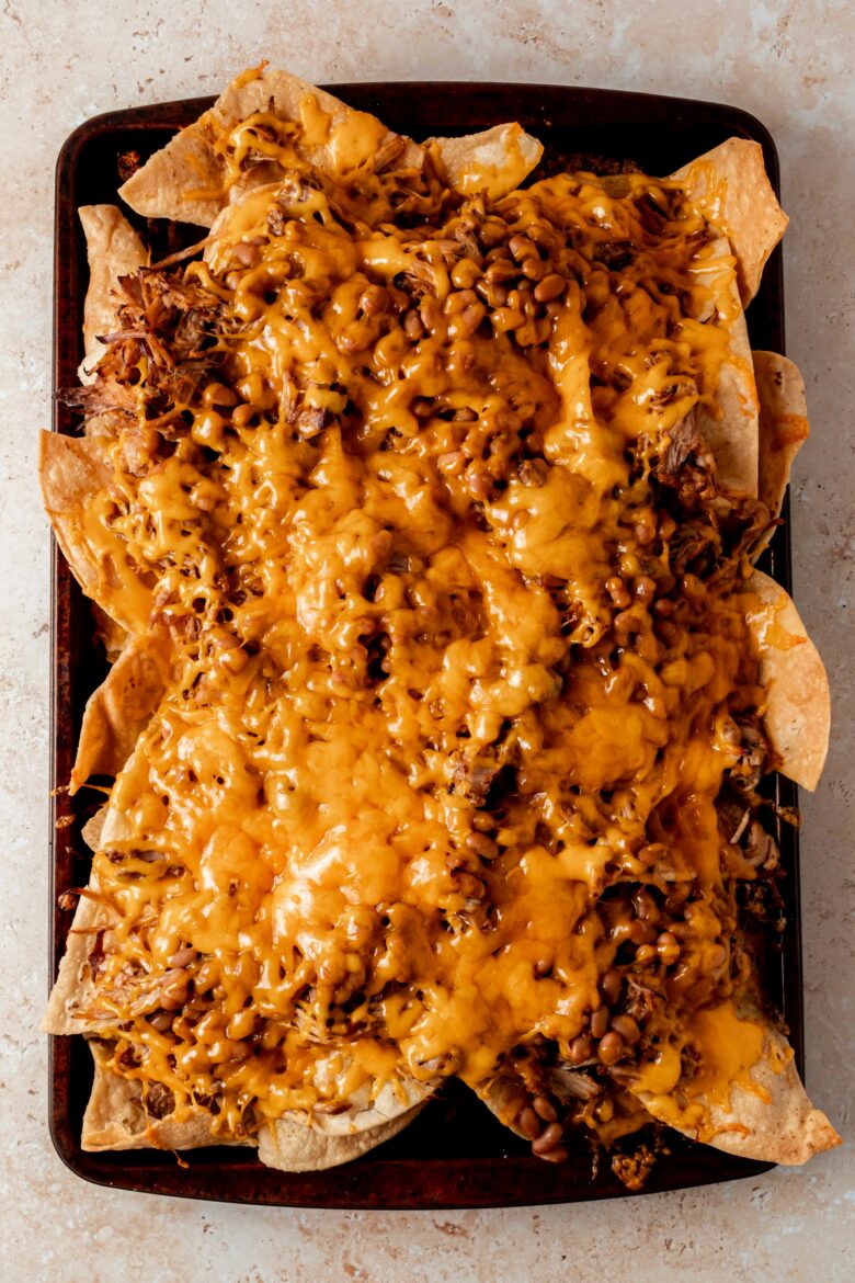Nachos right after baking with pulled pork, baked beans and shredded cheddar
