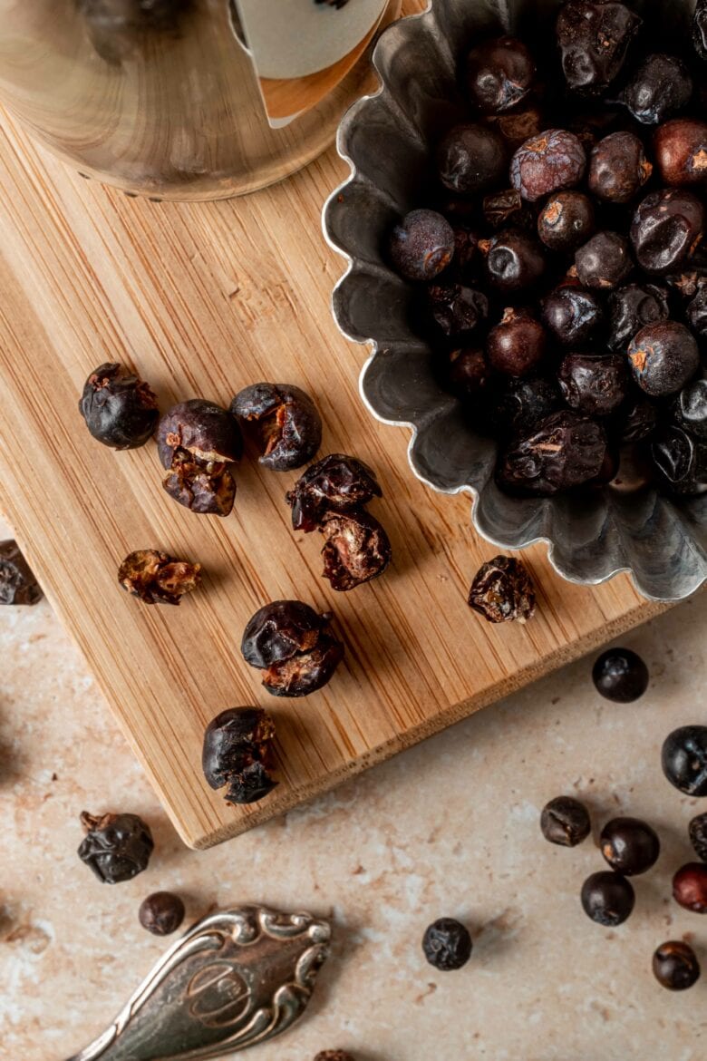 Crushed juniper berries on cutting board.