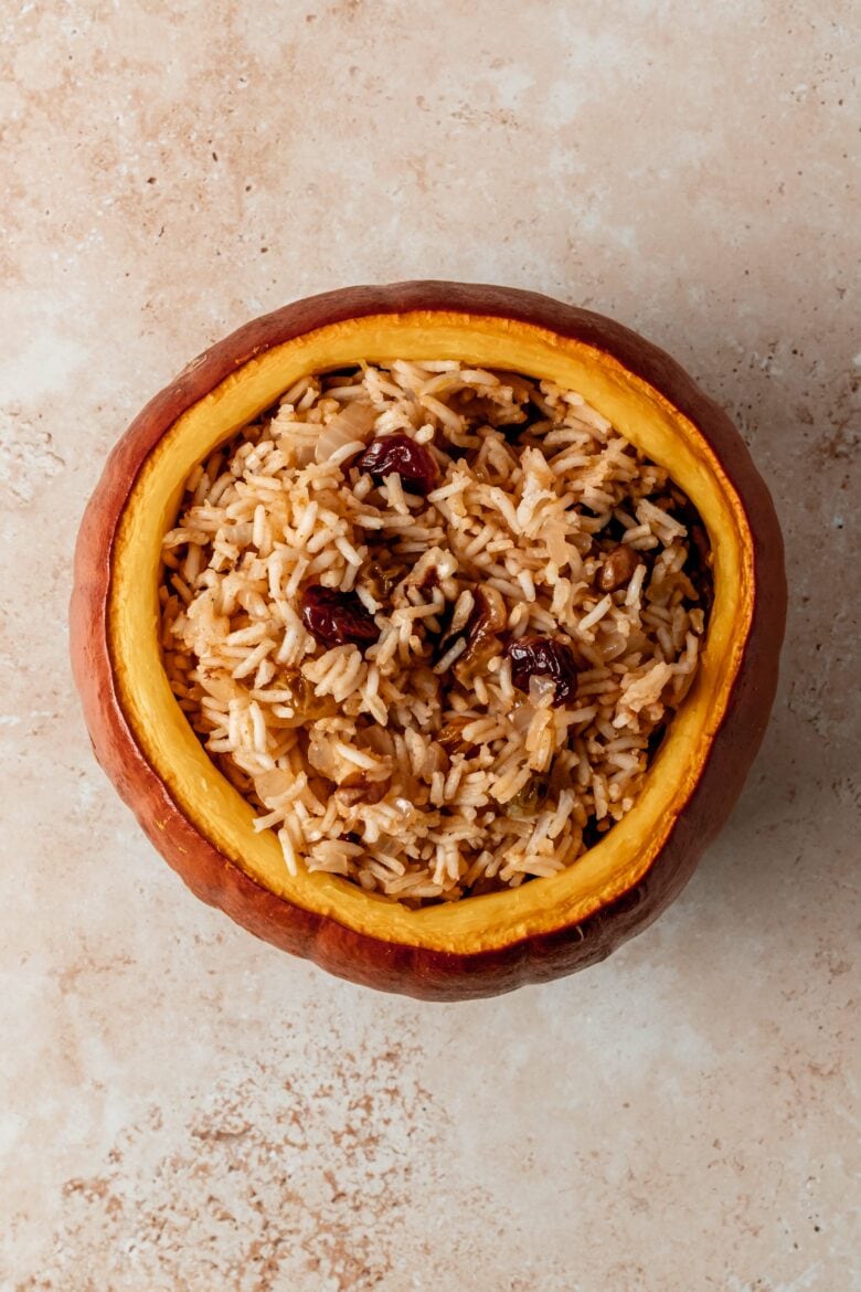 Rice, dried fruit and walnut stuffing in baked pumpkin.